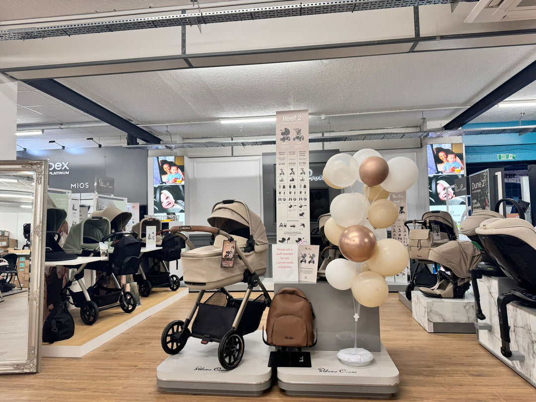 Interior of a baby and nursery store with various strollers and nursery furniture on display.