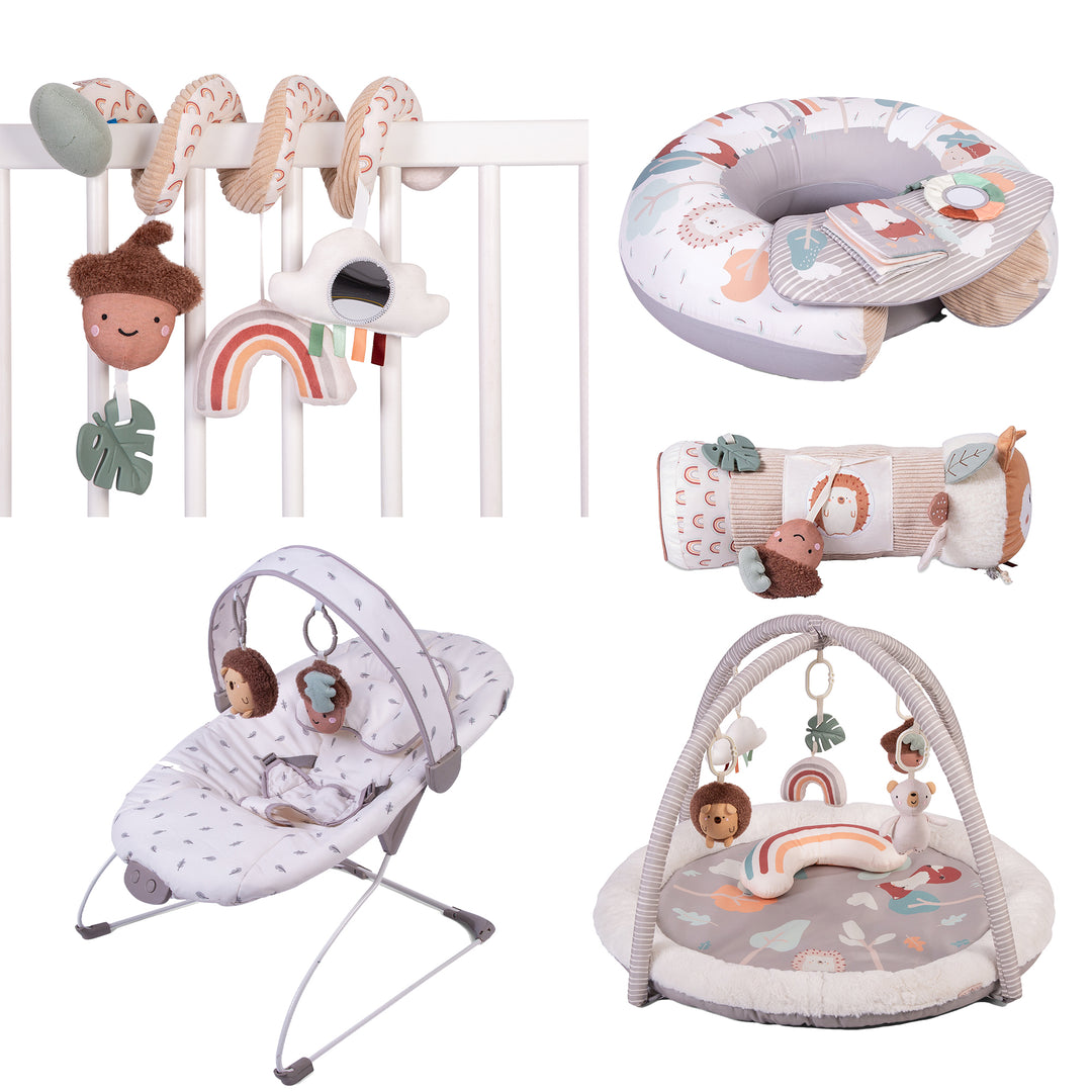 A collection of five baby activity toys from the Red Kite Woodland Walks range, including a play gym, sit me up cushion, spiral toy, tummy time roller, and a bouncer chair, all featuring woodland animal themes and colorful baby-friendly textures.