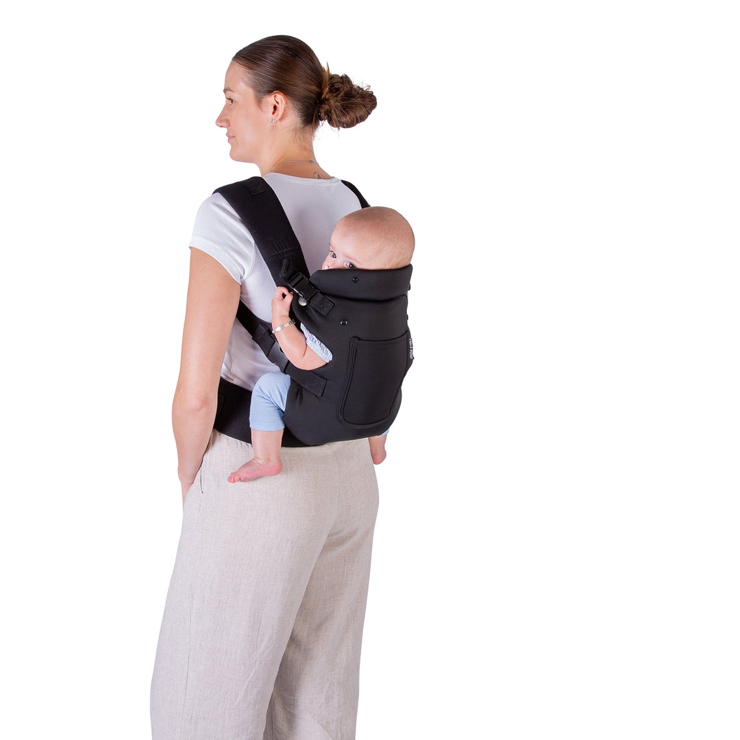Woman carrying a baby in a black baby carrier on a white background