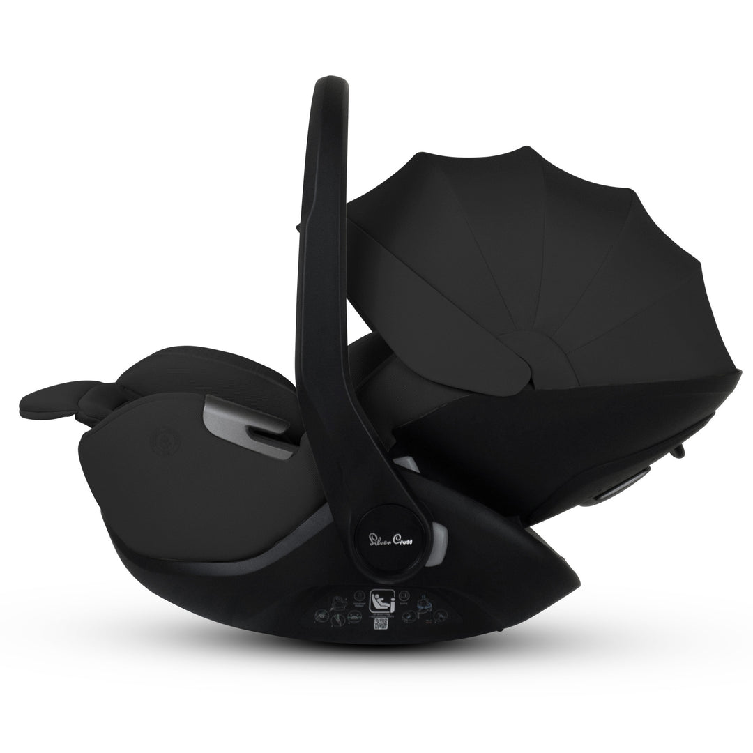 A black Silver Cross Plus i-Size Car Seat, a Red Dot award winner for 2025, designed for children from birth up to 19.5 kg, with dual functionality and a unique inner seat recline system.