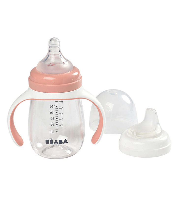 Beaba 2 In 1 Learning Bottle set including a transparent bottle with blue handles and measurement markings, a bottle teat, and a spout with two rings.