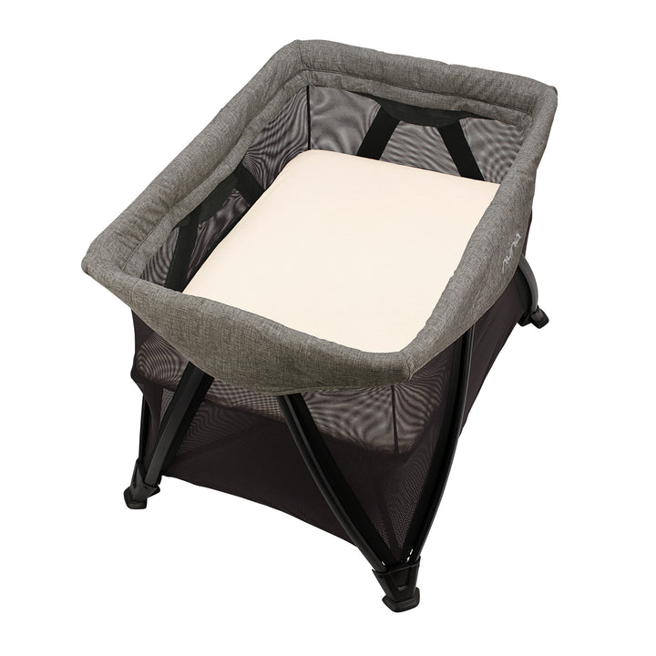 Gray and black baby bassinet with a white pillow on a white background