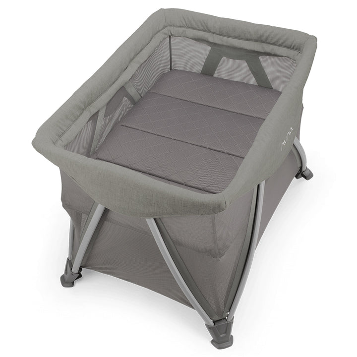 Gray baby crib with mesh side on a white background