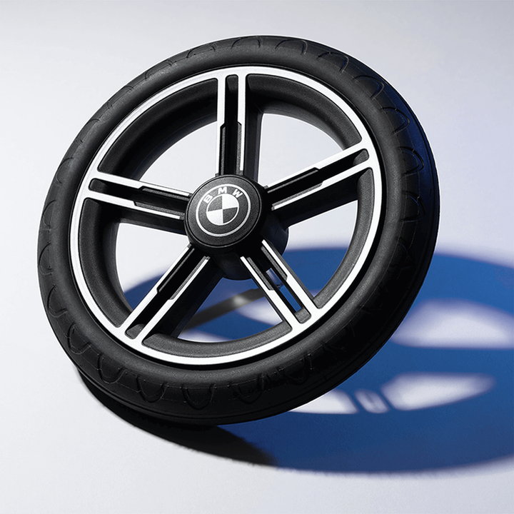Black BMW wheel on a reflective surface with a blurred background
