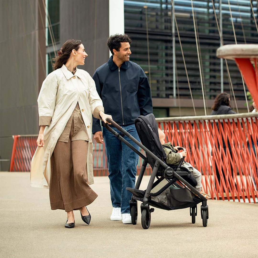 Man and woman walking with a stroller in an urban setting